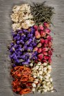 Вид зверху на сушені квіти і чайне листя на столі — стокове фото