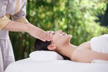 Recortado disparo de joven asiático mujer recibir cabeza masaje en spa salon - foto de stock