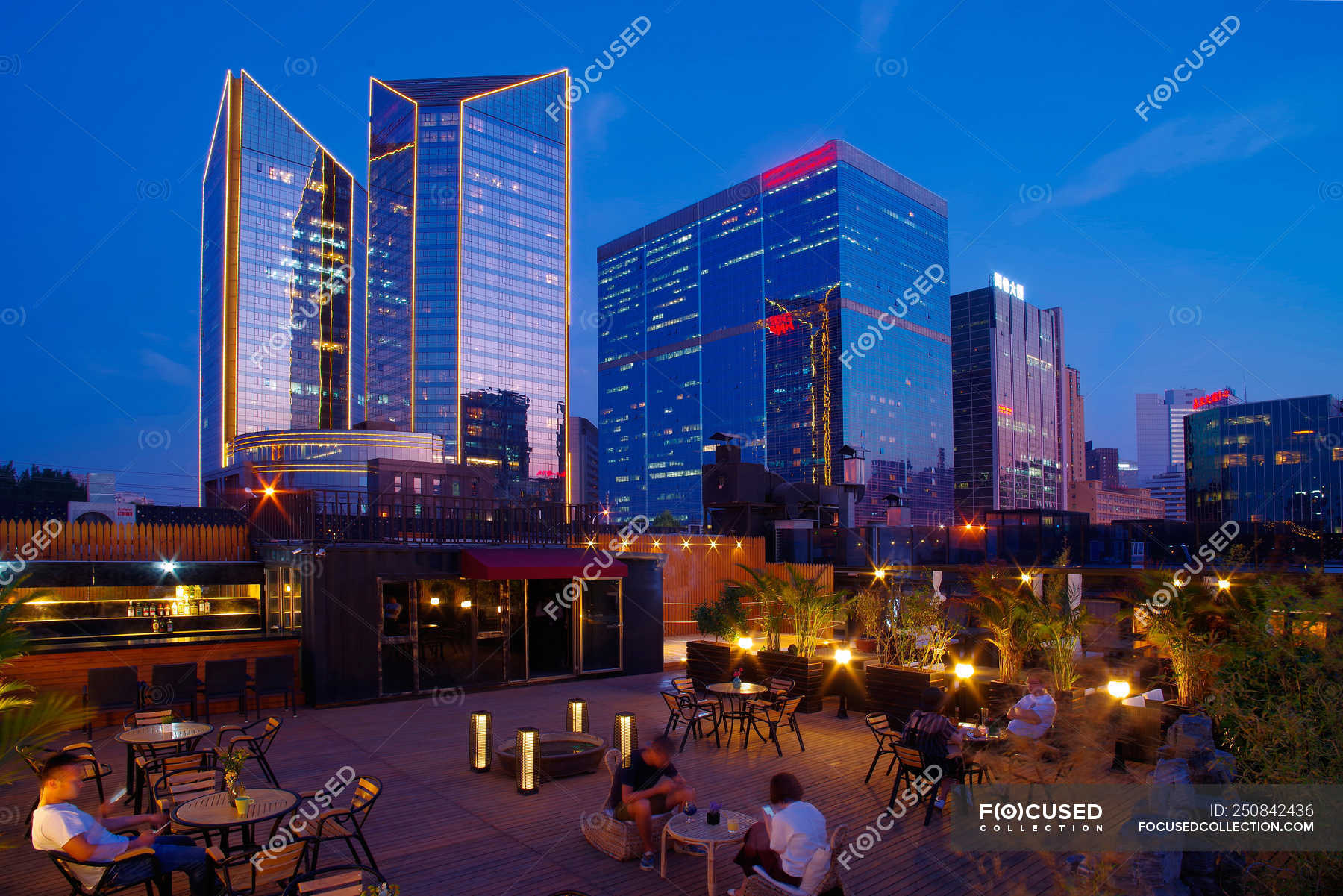 People Sitting On Chairs On Terrace And Beautiful Night City View Of Beijing China Cityscape Stock Photo