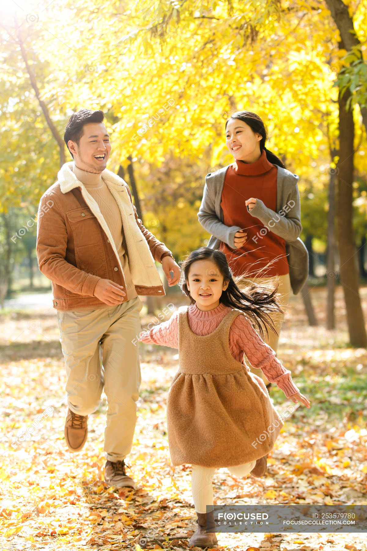 happy-asian-parents-and-daughter-running-in-autumnal-park-male