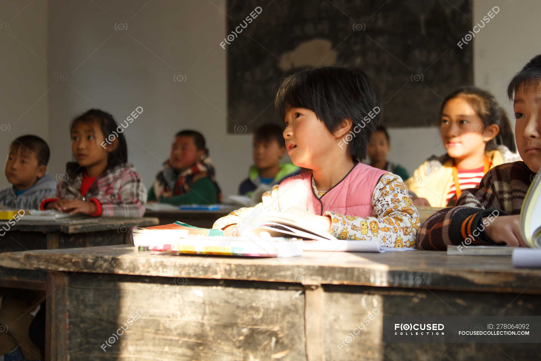 Chinese school students sitting at desks and studying in rural primary ...