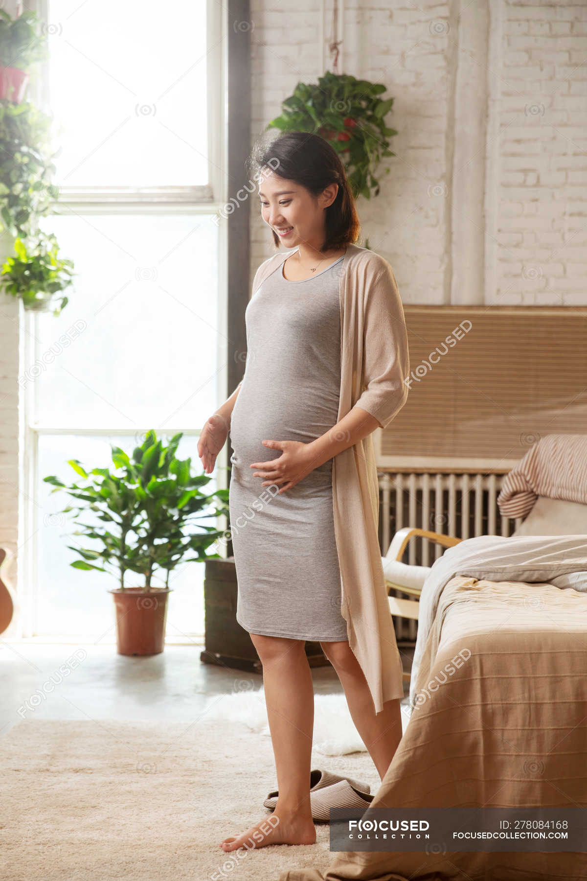 Beautiful Happy Young Pregnant Asian Woman Standing And Smiling In