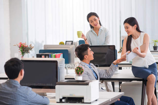 Profesional joven asiático hombres de negocios y mujeres de negocios trabajando con computadoras y discutiendo proyecto en oficina - foto de stock