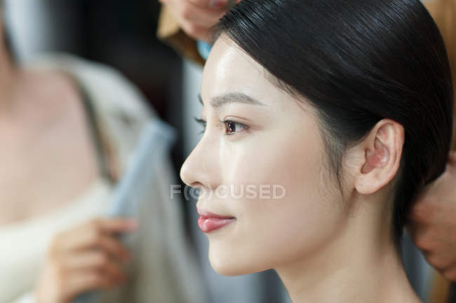 Corte tiro de estilistas fazendo penteado para bela jovem asiática mulher no salão de beleza, foco seletivo — Fotografia de Stock