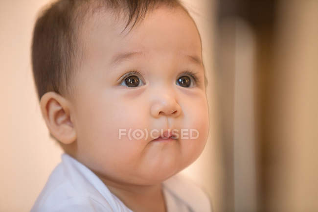 Nahaufnahme Porträt eines entzückenden asiatischen Säuglings, der zu Hause nach oben schaut — Stockfoto