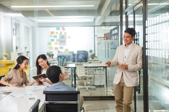 Feliz jovem asiático empresário olhando sorridente colegas trabalhando juntos no moderno escritório — Fotografia de Stock