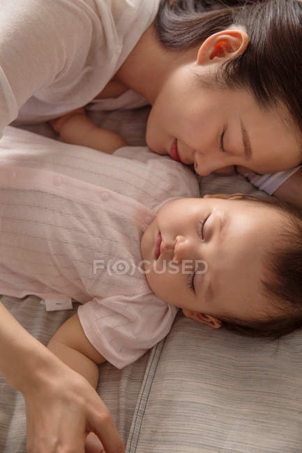 Vista superior de bela jovem mãe asiática e adorável bebê infantil dormindo juntos na cama — Fotografia de Stock