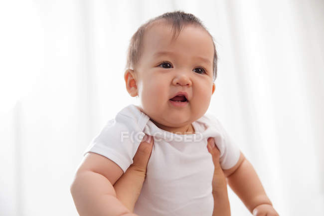 Plan recadré de parent portant bébé asiatique adorable à la maison — Photo de stock
