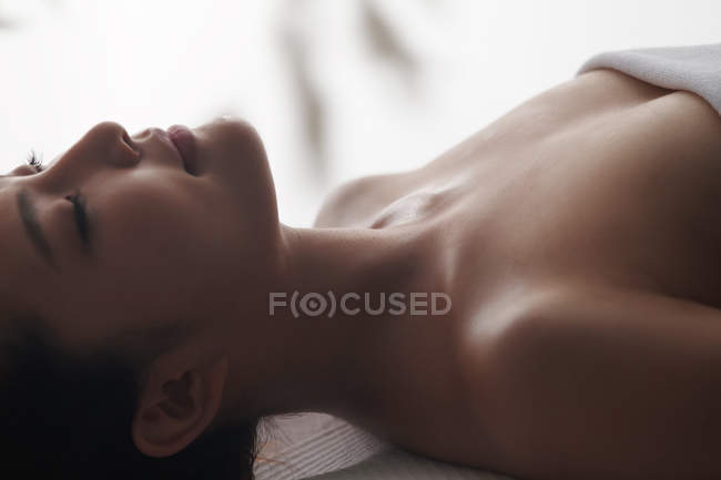 Крупним планом приваблива молода азіатська жінка з закритими очима, що розслабляються в спа-центрі — стокове фото
