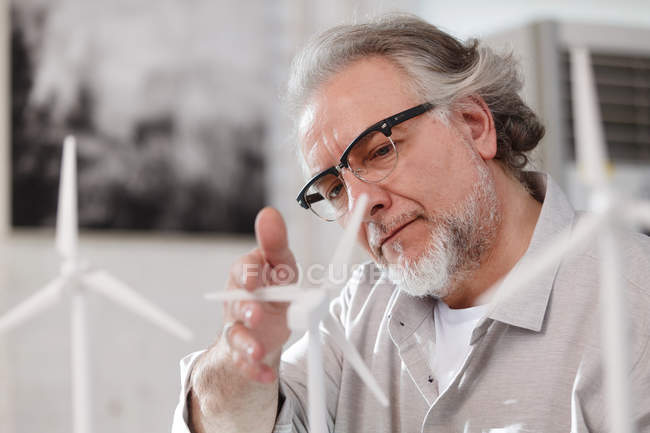 Focused mature architect in eyeglasses working with windmills in office — Stock Photo