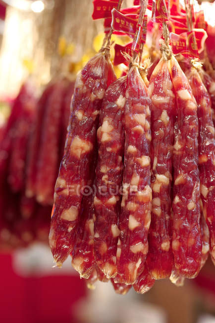Vista close-up de salsichas saborosas penduradas em cordas — Fotografia de Stock