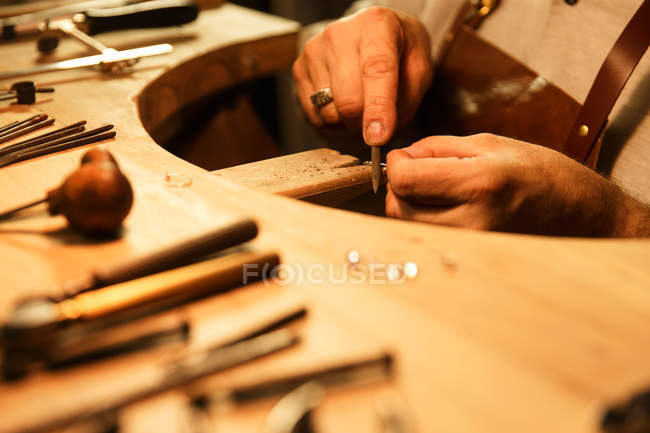 Vista de cerca del hombre que trabaja con herramientas y anillo en el taller, tiro recortado - foto de stock