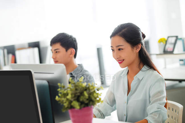 Професійні молоді азіатські ділові люди, що працюють з комп'ютерами в офісі — стокове фото