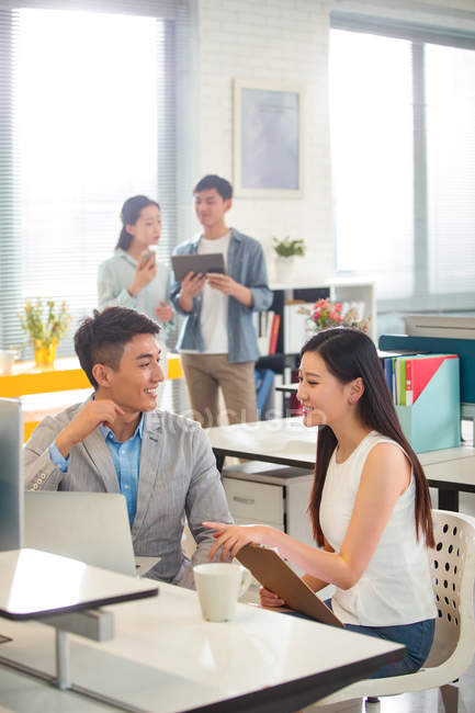 Sonriente joven asiático hombres de negocios y mujeres de negocios trabajando juntos en moderno oficina - foto de stock
