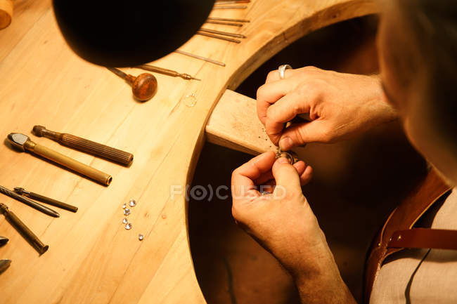Plan recadré de l'homme travaillant avec des outils et anneau en atelier — Photo de stock