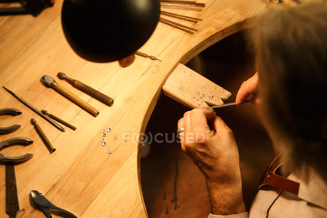 Close-up view of man working with tools and ring in workshop, cropped shot — Stock Photo