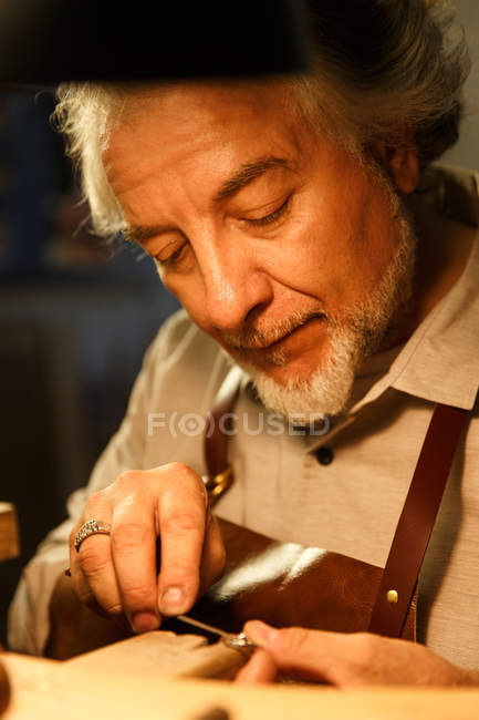 Close-up view of focused jewelry designer working with ring in workshop — Stock Photo