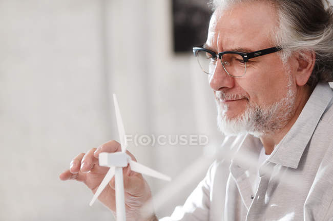 Concentrato professionista architetto maturo che lavora con modello mulino a vento in ufficio — Foto stock