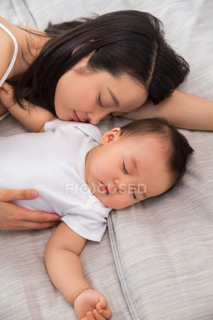 Alto angolo vista di asiatico madre e bambino dormire insieme su letto — Foto stock