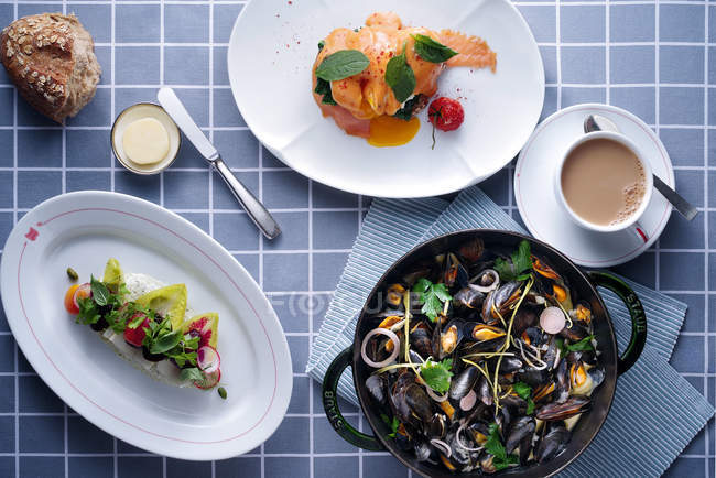 Blick von oben auf köstliche Gerichte, Drink und Muscheln in der Pfanne auf dem Tisch — Stockfoto