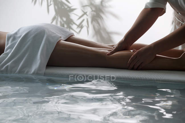 Обрезанный снимок молодой женщины, получающей массаж в спа-салоне — стоковое фото