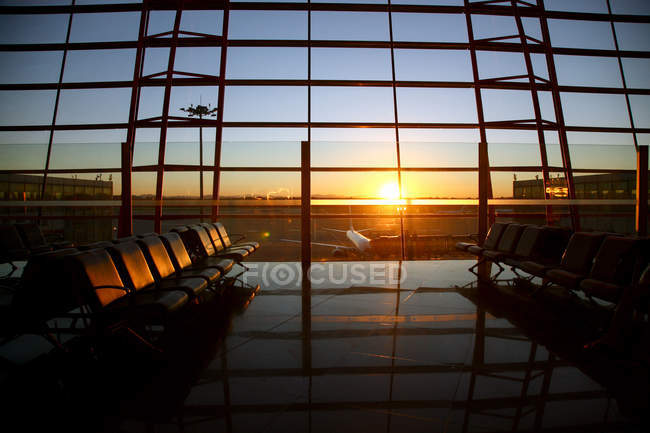 Внутри пустой современной гостиной аэропорта во время захода солнца — стоковое фото