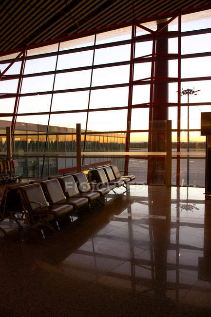 À l'intérieur du salon moderne vide de l'aéroport pendant le coucher du soleil — Photo de stock