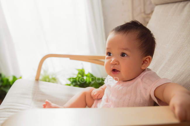Adorable asiatique bébé enfant assis sur rocking chair à la maison — Photo de stock
