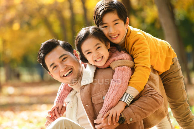 Щасливий батько з дітьми розважається в автономному парку — стокове фото
