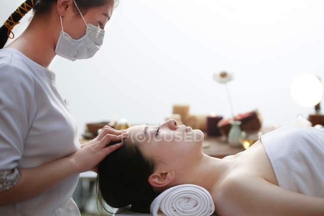 Молода азіатка отримує масаж голови в спа-салоні — стокове фото