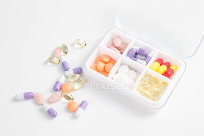 Hochwinkelaufnahme von Pillen im Tagesgebinde auf weißer Oberfläche — Stockfoto