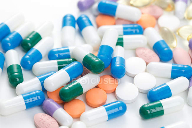 Розкидані таблетки на білій поверхні — стокове фото