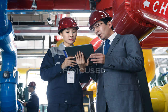 Technisches Personal mit harten Hüten arbeitet in der Fabrikinspektion zusammen — Stockfoto