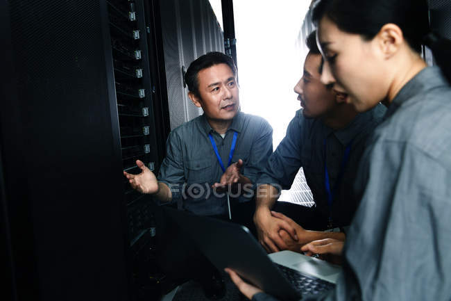 Технічний персонал, що працює з ноутбуком у кабінеті технічного обслуговування — стокове фото