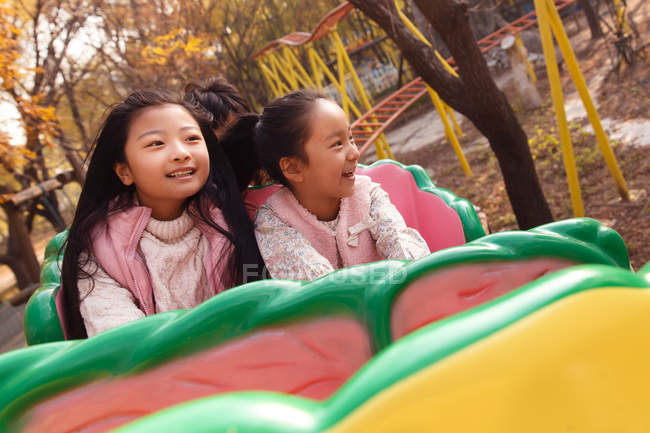 Щасливі дівчата грають разом на роликових гірках в парку — стокове фото