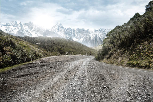 Paysage étonnant avec route rurale vide et montagnes pittoresques pendant la journée — Photo de stock