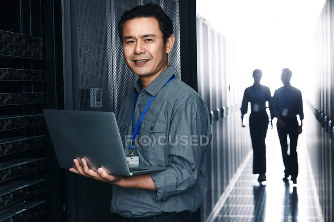 Pessoal técnico que trabalha com computador portátil na inspecção da sala de manutenção — Fotografia de Stock