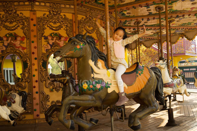 Adorable happy little girl playing with carousel — Stock Photo