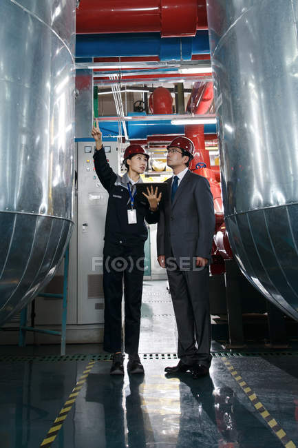 Ingegneri cinesi in cappelli duri che lavorano insieme nell'ispezione della fabbrica — Foto stock