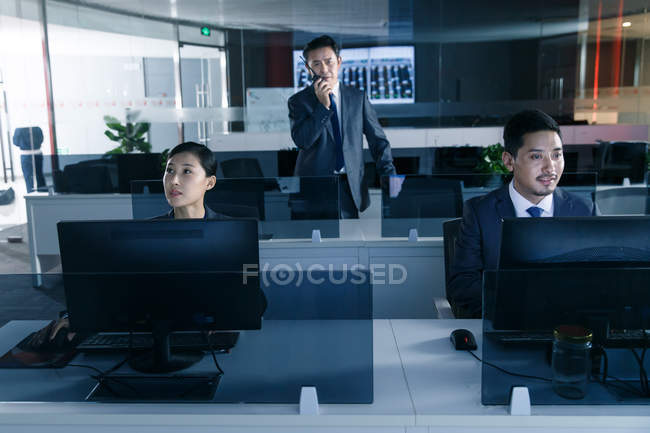 Професійні бізнесмени, що працюють з комп'ютерами в контрольній кімнаті — стокове фото
