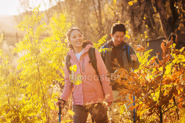 Ásia casal trekking no outonal floresta — Fotografia de Stock