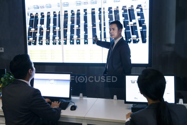 Professionelle asiatische Geschäftsleute arbeiten im Kontrollraum zusammen — Stockfoto