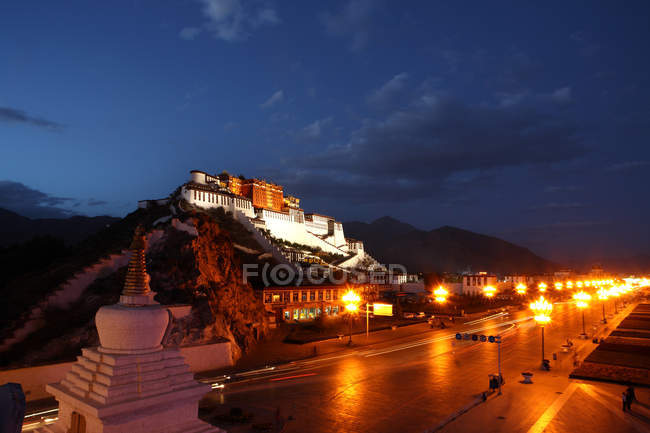 Vista de ángulo alto del palacio iluminado de Potala en Lhasa en el Tíbet por la noche - foto de stock
