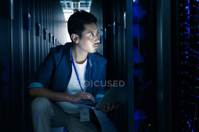 Людина використовує портативний комп'ютер і працює в технічному обслуговуванні кімнати огляду — стокове фото