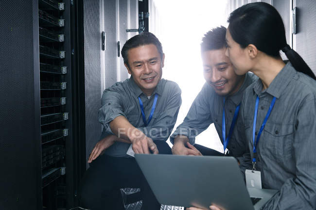 Personnel technique travaillant avec un ordinateur portable lors de l'inspection de la salle de maintenance — Photo de stock