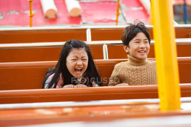 Happy boy and girl playing together in the playground — Stock Photo