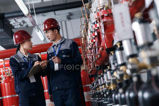 Professionelle Ingenieurinnen und Ingenieure in harten Hüten arbeiten in der Werksbrandinspektion — Stockfoto