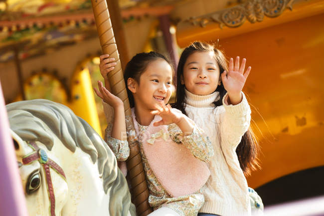 Mignon joyeux petites filles jouer avec carrousel — Photo de stock