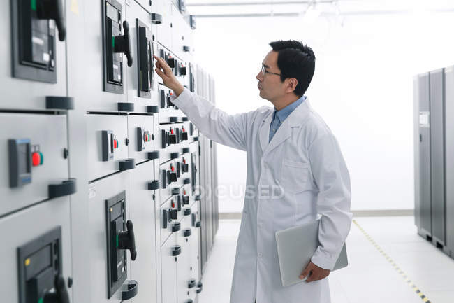 Technical personnel in white coat working in the voltage room — Stock Photo