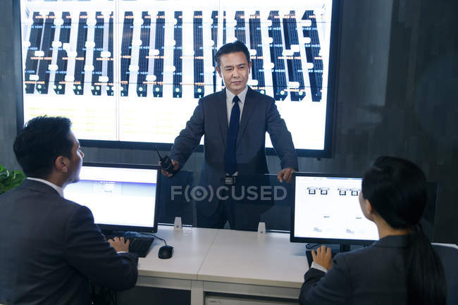 Professional business people working together in the control room — Stock Photo